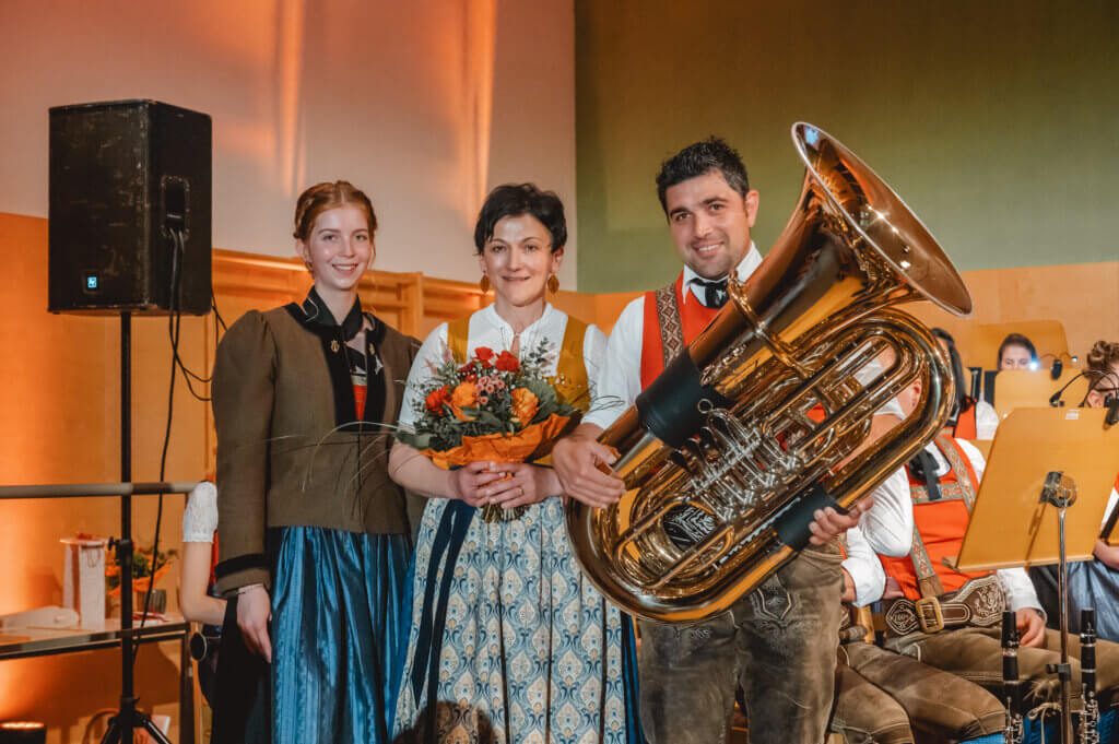 Musiker der Trachtenmusikkapelle Taxenbach in traditioneller Tracht mit Tuba und Blumenstrauß