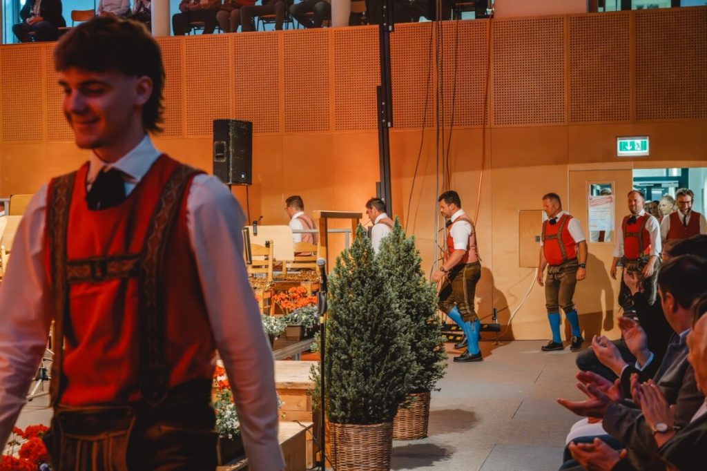 Mitglieder der Trachtenmusikkapelle Taxenbach in traditioneller Kleidung bei Auftritt im Saal